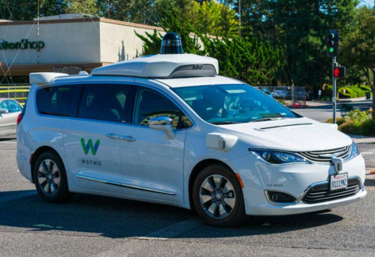 Waymo self driving car performing driving tests on the street.