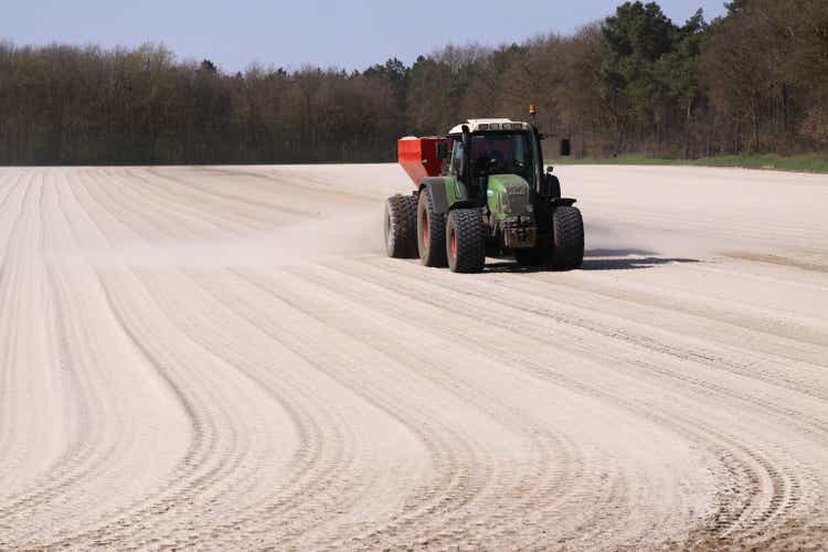 Kreidedünger-Anwendung per Traktor mit Streuer, um das Feld für den Rasenanbau vorzubereiten