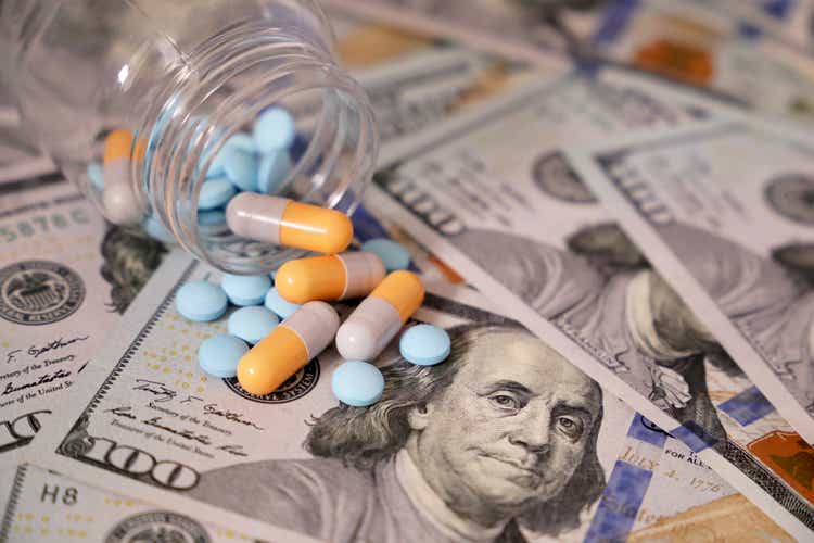 Pills and capsules in a bottle on US dollar bills