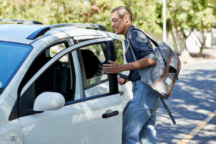 Male students get on the bus on the roadside