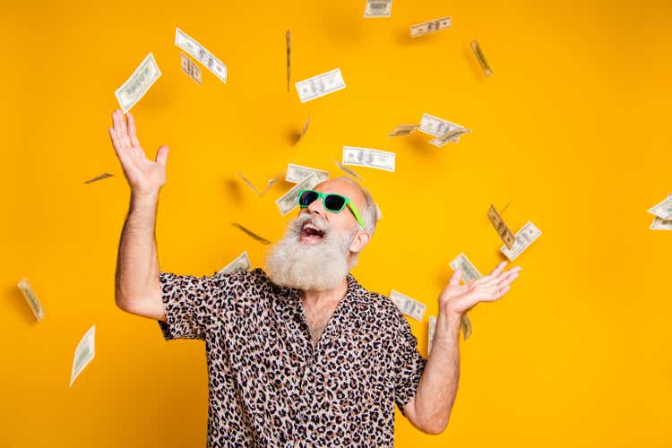 Portrait of crazy funky funny old bearded man hipster in green eyeglasses, eyewear look up at money falling scream great win lottery wear leopard stylish shirt isolated over yellow background