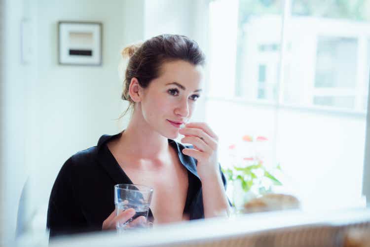 Woman taking vitamins and supplements.