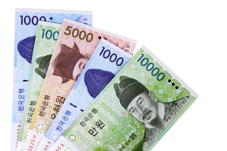 Korean Won currency bills are fanned out on a white surface
