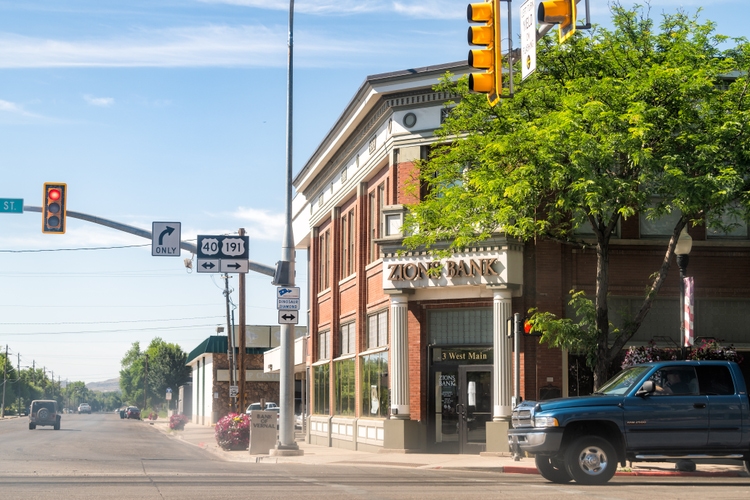 Utah city street with Zions Bank and cars on road in town near Dinosaur National Monument