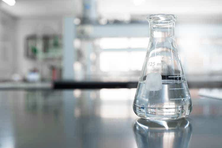 single glass flask with water in chemistry education laboratory background