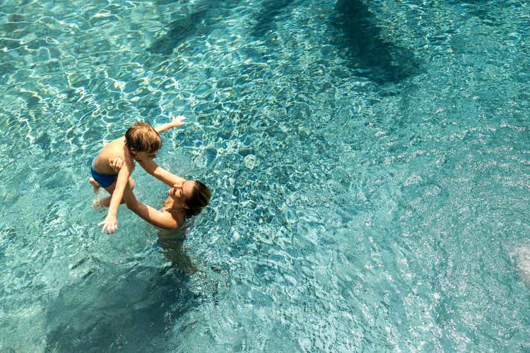 Above view of happy single mother and her son having fun in the pool.