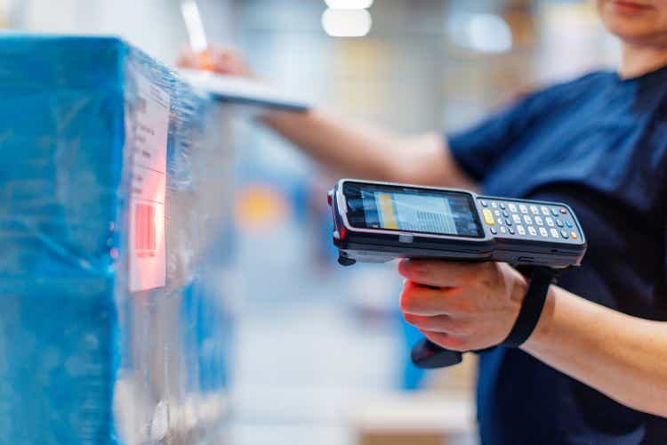 Woman with barcode reader in warehouse