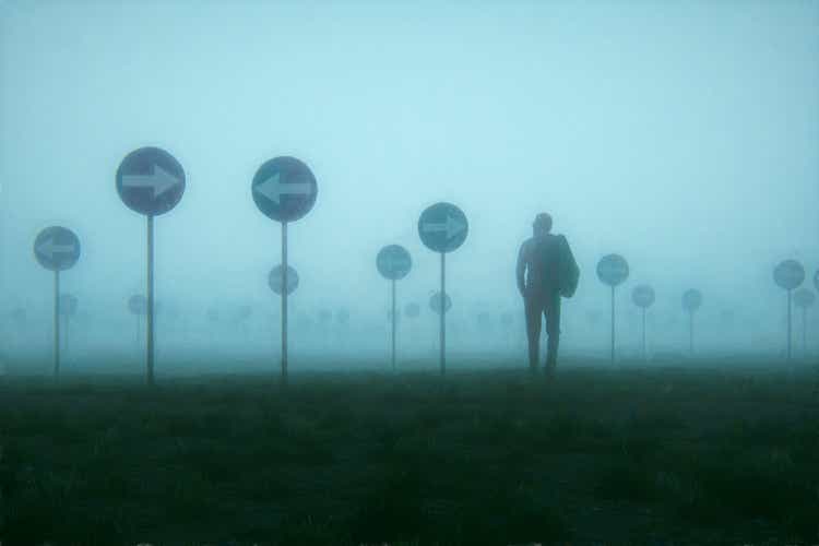 Lost and confused businessman walking in meadow