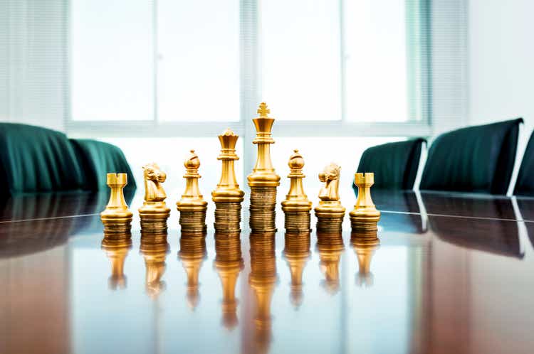 Chess pieces standing on the stacked coins