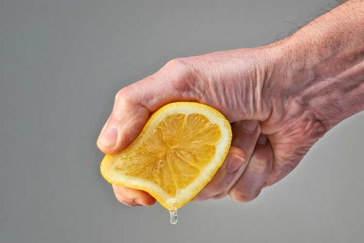 Male hand pressing a half lemon fruit