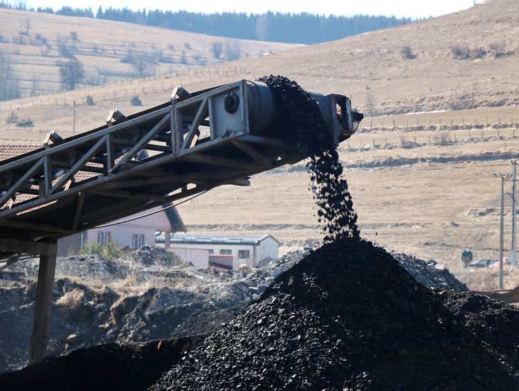 Coal falling from the moving belt conveyor into the big pile