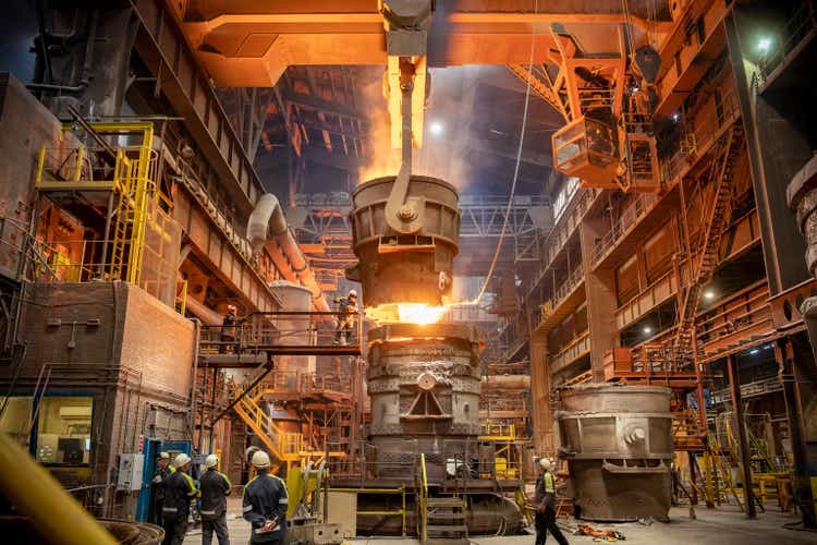 Steelworkers looking on during steel pour in steelworks