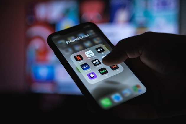 Apple XS Smartphone in Hand with Group of Streaming Applications