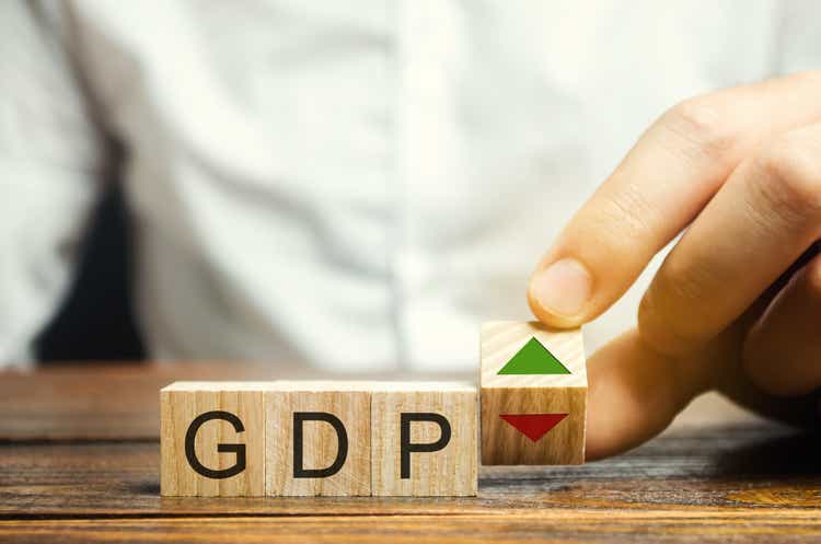 Wooden blocks with the word GDP and up and down arrows. An unstable economy in the country. Financial measure of the market value of all the final goods and services produced in a specific period.