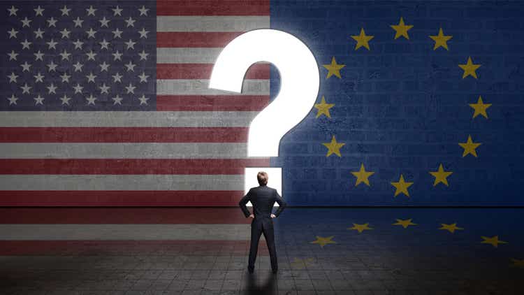 businessman standing in front of a wall with a questionmark and the flags of the usa and the european union