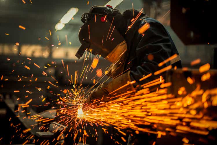 A metal worker uses a grinder