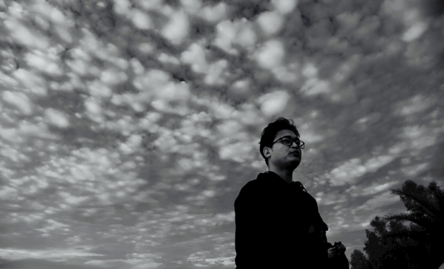 Man standing in a place with cloudy sky background