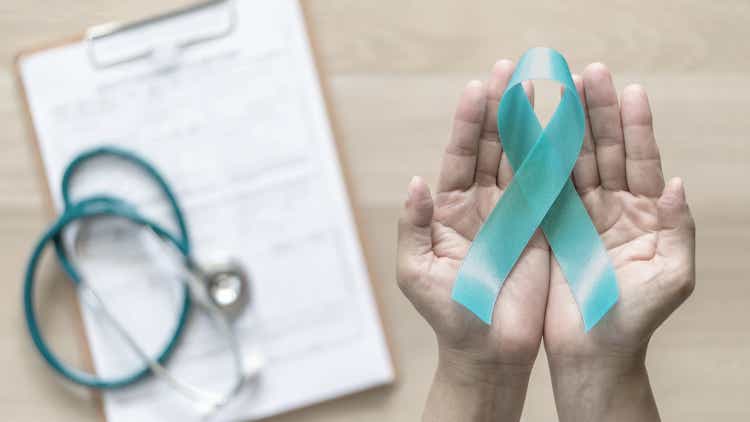 Teal ribbon awareness on woman"s hand for Ovarian Cancer, Polycystic Ovary Syndrome (PCOS) disease, Post Traumatic Stress Disorder (PTSD), Tourette"s Syndrome, Obsessive Compulsive Disorder (OCD)