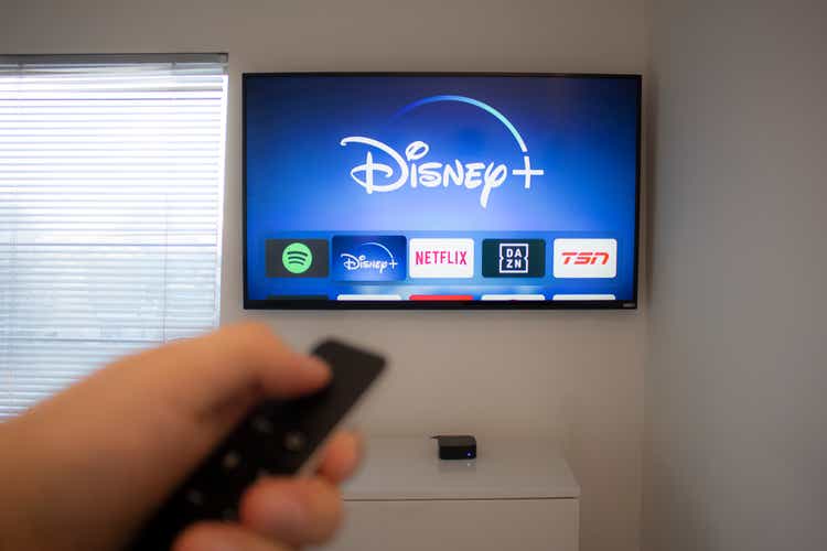 Person tiene un control remoto de Apple TV usando la nueva aplicación Disney+ en un Vizio TV. El servicio de streaming de vídeo de Disney+ mostrará exclusivamente Star Wars: Jedi Template Challenge.
