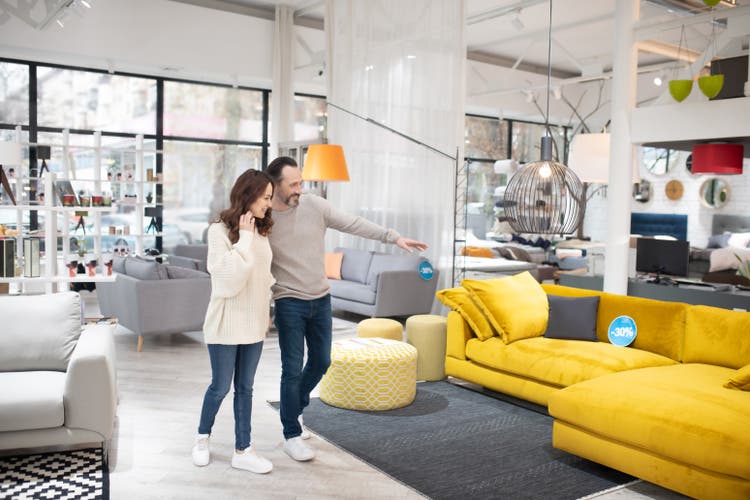 Two people discussing furniture models in a modern furniture shop