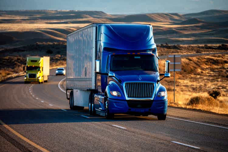 Long Haul Semi-Truck Rolling Down a Four-Lane Highway at Dusk