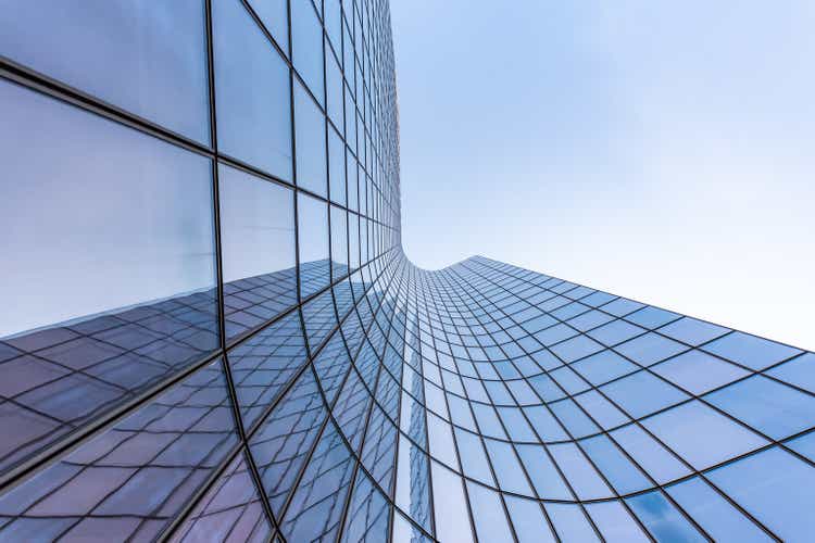 Blue curved glass skyscraper facade against sky