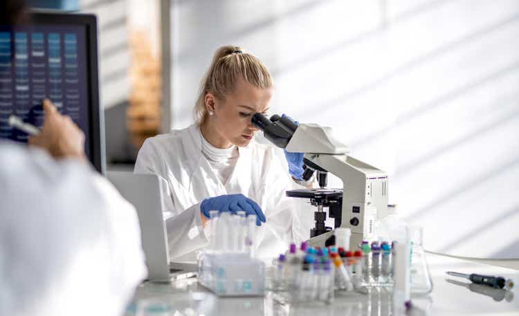 Female scientist looking through a microscope