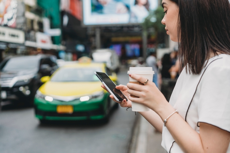 Young adult businesswoman looking for a taxi with a mobile phone