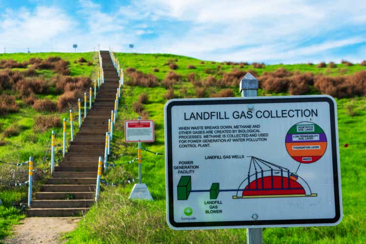 Sign at former landfill explains how the landfill gas collected and used for power generation Trail stairs lead to the top of the green hill