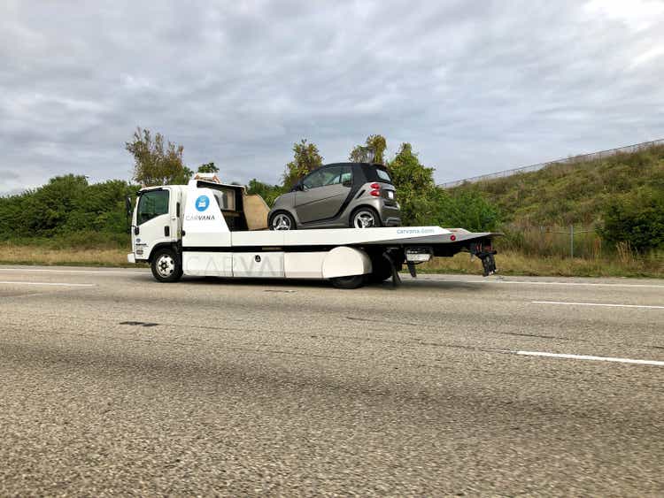 Carvana rollback delivery truck on highway with Smart Car12/22/2019 Orlando FL- Carvana delivery truck with Smart car on deck