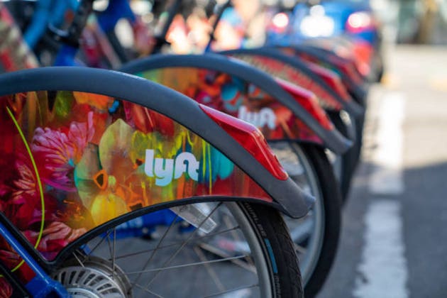Row of Lyft Bikes sitting at bikeshare docking station on street