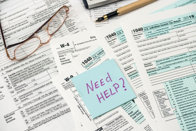 Dollar, calculator and pen with 1040 tax form