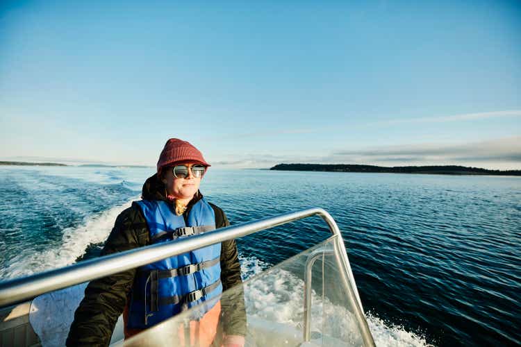 Portrait of woman driving outboard boat on fall morning