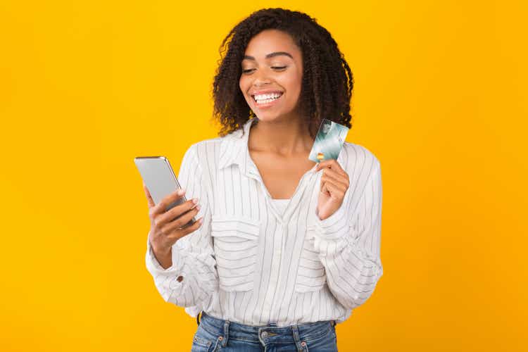 Femme noir retenant la carte de crédit et le téléphone portable