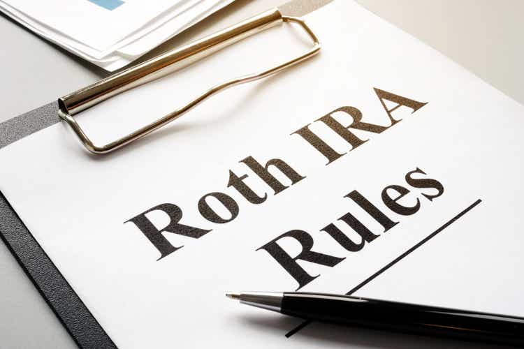 Roth IRA rules with stack of papers and pen.