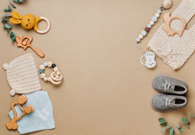 Wooden toys, clothes and shoes on beige background