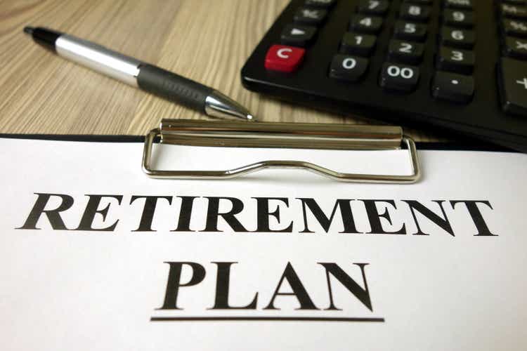 Text retirement plan on paper sheet with pen and calculator