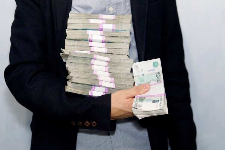 large stack of paper money in the hand of an adult businessman. concept of financial success. a lot of money in men"s hands
