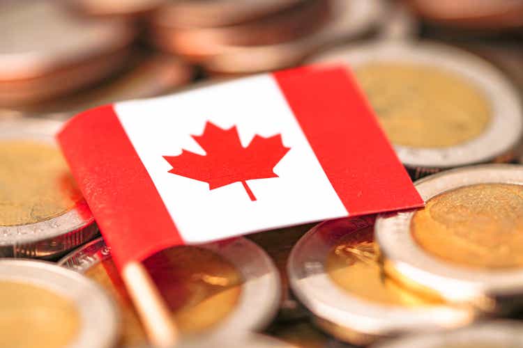 Canada Flag on coins background : Business and finance concept.