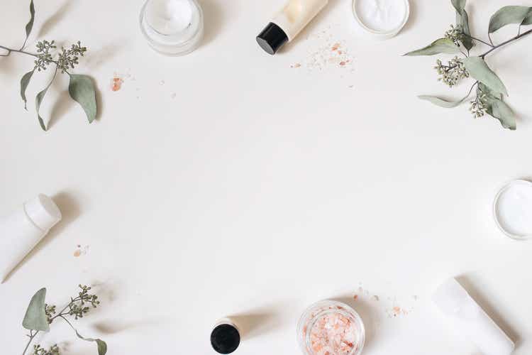 Skin cream, shampoo bottle, dry eucalyptus leaves and pink Himalayan salt. White table background. Styled beauty frame, web banner. Organic cosmetics, spa concept. Empty space, flat lay, top view.