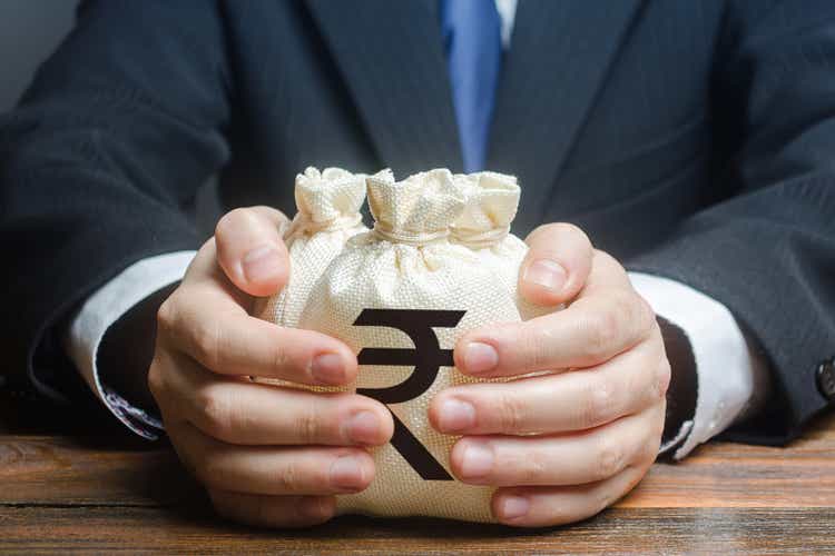 Businessman hugs indian rupee money bags. Granting financing business project or education. Trade, economics. Corruption. Provision financial loan credit. Bank deposit. Budget, tax collection.