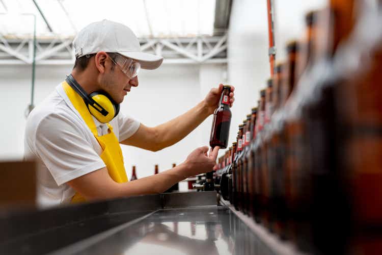 Man supervising the operation of a bottling machine