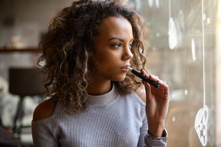 Young woman vaping in a bar