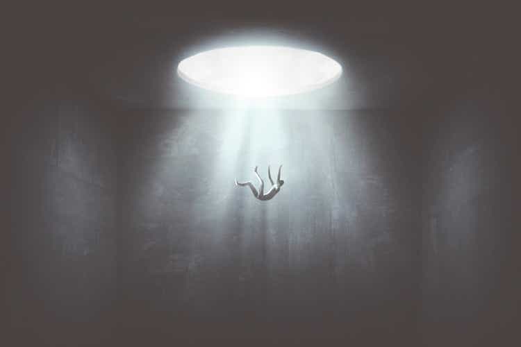 man falling down from a hole of light, surreal concept