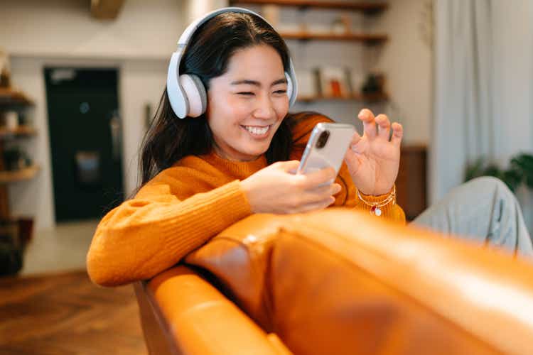 Stylish young woman listening to music at home