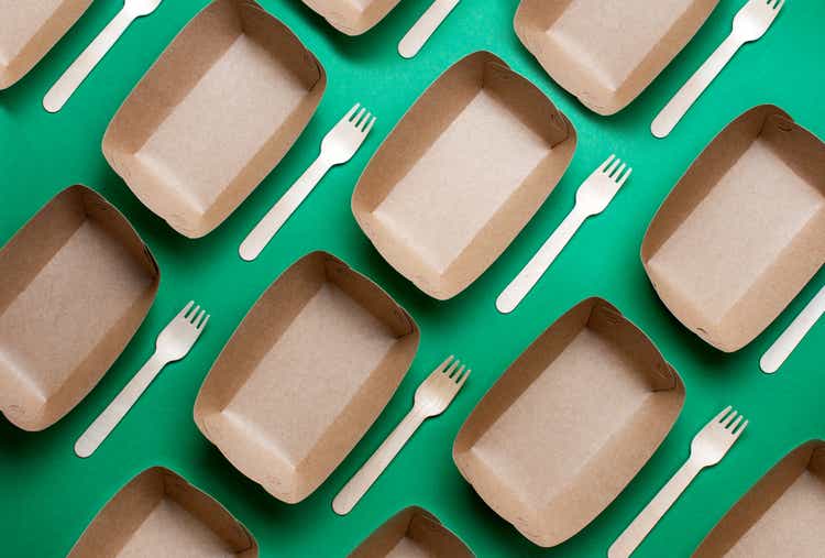 Brown kraft paper food containers on green background