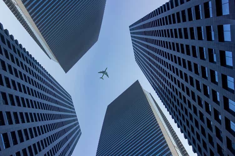 Een vliegtuig vliegt over een commercieel gebouw