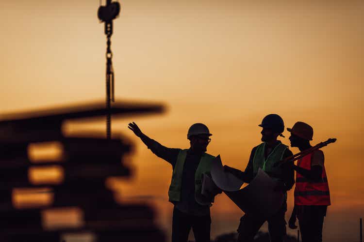 Construction workers discuss the building plans