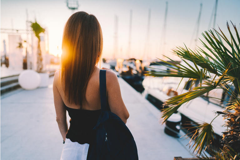 Woman at the marina staring the sunset