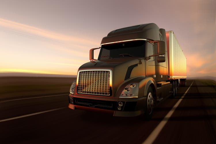 a cargo truck on the road at sunset